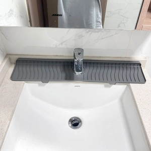 Macro detail of grey silicone sink faucet mat with wave drainage grooves for water runoff