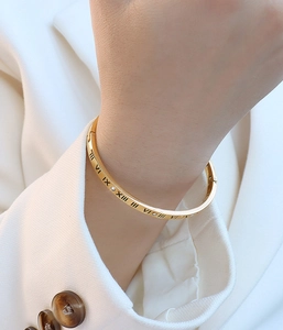 Detail of 18k gold plated bangle featuring Roman numerals and sparkling cubic zirconia