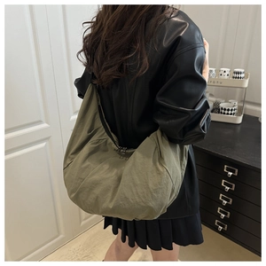 Sac croissant en nylon vert olive montrant sa grande capacité et sa texture plissée