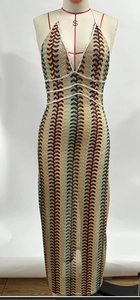 Détail d'une robe bohème en maille avec motifs ondulés rouge-jaune-vert et taille blanche