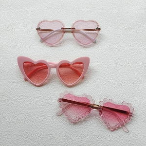 Three pairs of stylish pink heart-shaped sunglasses for kids in various fashion frames
