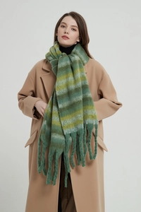 Detail of green and yellow striped knit scarf with long tassels over a wool coat