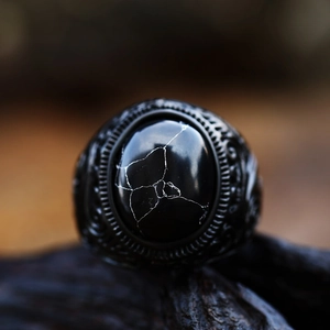 Dettaglio di un anello vintage in acciaio nero con gemma incastonata a trama di ragnatela