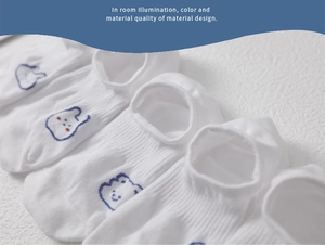 Close-up of white low-cut invisible socks with delicate blue animal embroidery details