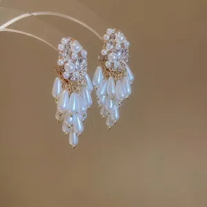 Elegant gold drop earrings featuring white pearls and marquise crystals with tassel fringe