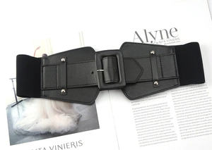 Detail of black elastic wide waist belt with PU leather front and metal buckle on magazine