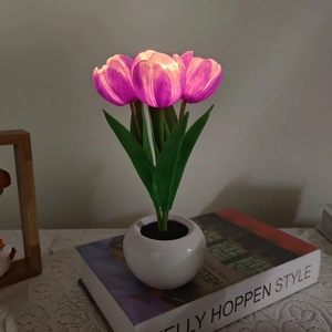 Detailed view of purple LED tulip night light in a white ceramic pot on a book