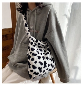 Detail shot of the plush cow print crossbody bag showing its soft texture and large capacity