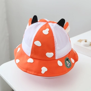 Detail of orange mesh sun hat for kids featuring cute black horns and cartoon patch