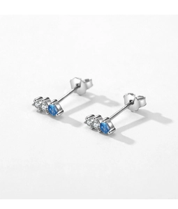 Macro view of floral silver stud earrings with oval blue stone and white zircons