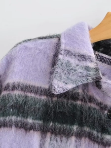 Macro shot of purple plaid wool coat fabric with textured brushed finish and collar detail