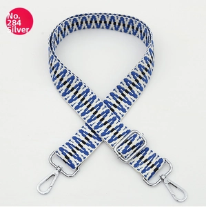 Detail of adjustable woven bag strap with blue and black geometric V-pattern and silver hooks