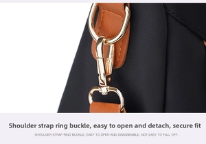 Close-up of detachable golden metal hook and brown leather strap on a black nylon backpack