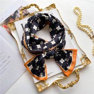 Double-sided floral silk scarf in navy blue and orange on a golden vintage tray