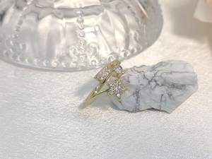 Detailed view of a gold star-shaped ring featuring pavé cubic zirconia on a white stone