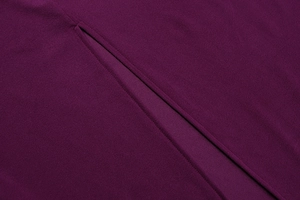 Detail of deep purple knit fabric showing high-quality stitching and a side slit design