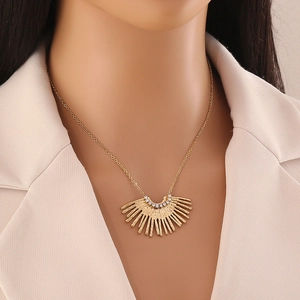Gros plan d'un collier doré en forme d'éventail avec cristaux sur un mannequin