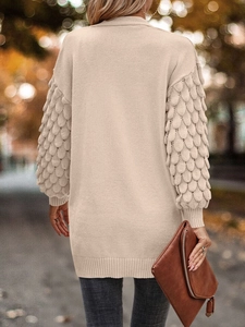 Detailed back view of beige knit cardigan showing leaf texture and loose silhouette