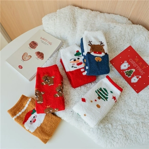 Détail de chaussettes de Noël en polaire corail douce avec motifs de renne et de Père Noël