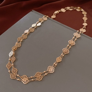 Detail shot of vintage double-layer gold metal necklace with hollow clover leaf pattern