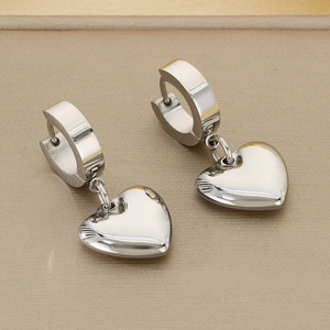 Macro detail of polished stainless steel heart earrings with shiny silver dangle pendants