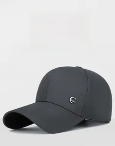 Dettaglio cappellino grigio scuro con logo in metallo argentato e twill di cotone