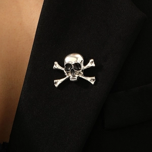 Macro shot of a silver skull and crossbones brooch pinned on a black suit lapel detail