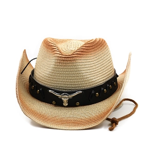 Detail of western straw hat with faux leather band and silver ox head metal ornament