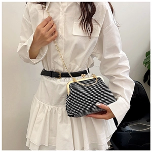 Close-up of elegant black evening clutch with sparkling rhinestones and gold chain