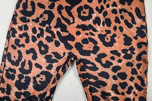 Close-up of leopard print stretchy fabric with brown and orange animal patterns