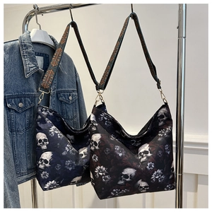 Large nylon bucket bag with skull floral prints and wide crossbody strap on display