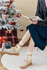Detail of Christmas reindeer knit socks with elastic cuffs in a cozy festive setting