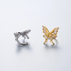 Detail of silver and gold butterfly ear cuffs with sparkling zircon stone inlays