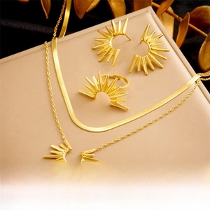 Détail de parure bijoux tournesol dorée avec boucles d'oreilles, bague et collier double
