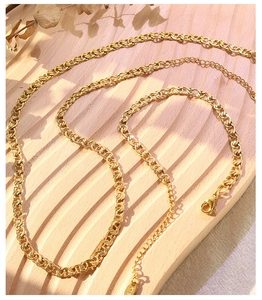 Detailed macro view of 18k gold interlocking chain necklace with K18 hallmark on wood