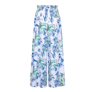 Close-up of high-waisted wide-leg pants with tropical leaf print and elastic waistband