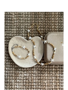 Detail of bohemian starfish beaded necklace and bracelet on a heart-shaped tray