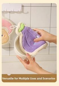 Detail of hand using a purple eggplant-shaped coral fleece cloth to wipe a ceramic bowl