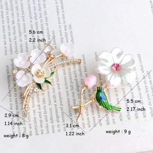 Vintage floral brooches with rhinestones and bird motif on antique book page