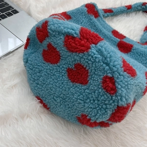 Detailed close-up of blue faux shearling fabric featuring a red heart pattern on the bag