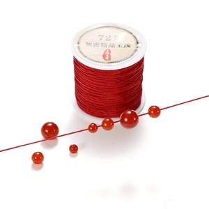 Close-up of 0.8mm red braided cord and matching round beads for DIY jewelry making
