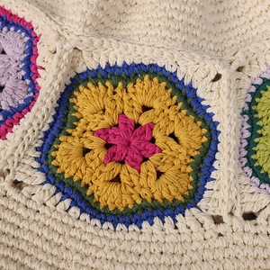 Handmade crochet bucket hat with colorful floral patterns on beige cotton yarn fabric