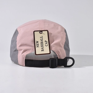 Close-up of pink and grey camp cap featuring a black adjustable strap and brand tag