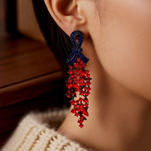 Vue détaillée de boucles d'oreilles vintage à nœud avec cristaux rouges et bleus sur mannequin
