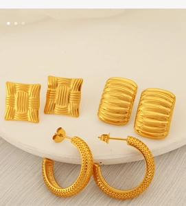 Detailed set of three gold-plated textured earrings on a white minimalist stone tray