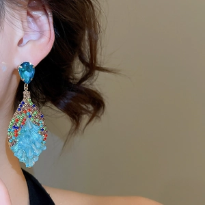 Close-up of Bohemian drop earrings featuring blue teardrop stones and colorful crystal accents