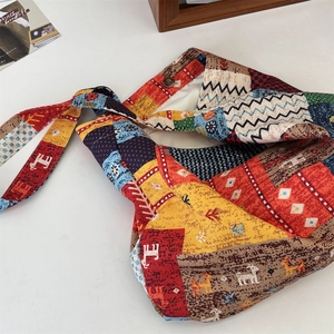 Detail of vintage patchwork canvas bag showing colorful textures and magnetic snap closure