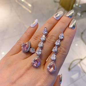Macro view of pear-cut pink gemstone ring and matching earrings with silver settings