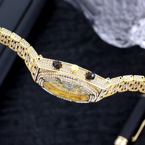 Close-up of luxury gold iced-out watch with crystal-encrusted bezel and side buttons