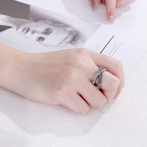 Detail of vintage silver criss-cross ring with black zircon inlays on model hand